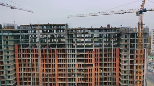 View of building at construction site. Aerial flight over new constructions site development