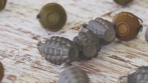 Military Grenades Rolling and Scattering on Wooden Table