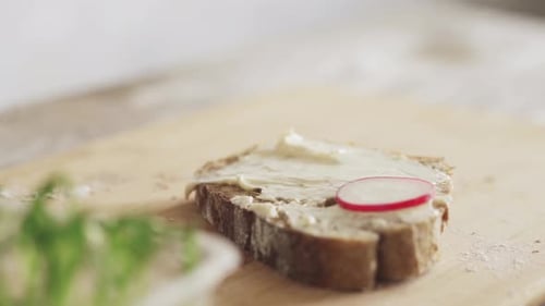 Preparing Sandwich With Radishes On Wooden Cutting Board