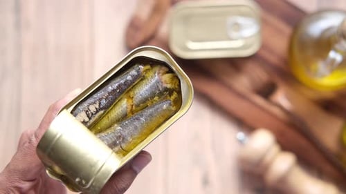 Holding a Can of Sardines in Oil