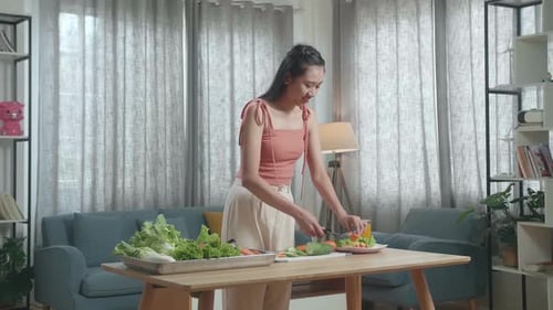 Young Woman Cutting Fresh Vegetables For Salad At Home