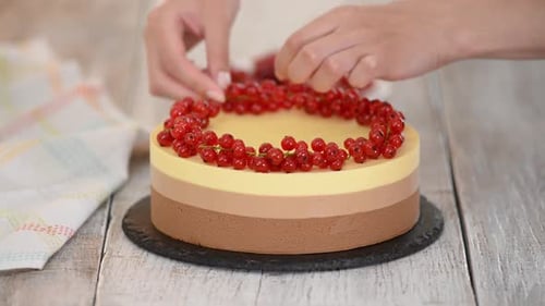 Hands Decorating a Triple Layer Dessert Cake