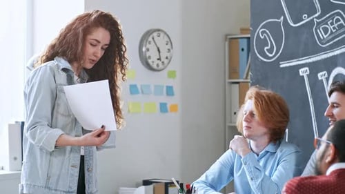 Young Woman Presents to Colleagues in a Meeting