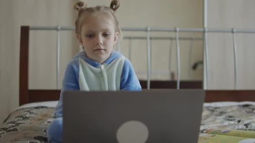 Girl Uses Laptop While Sitting on Bed