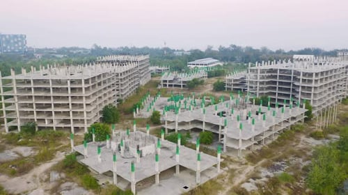 Aerial top view of abandoned apartment or hotel under construction site with structure.