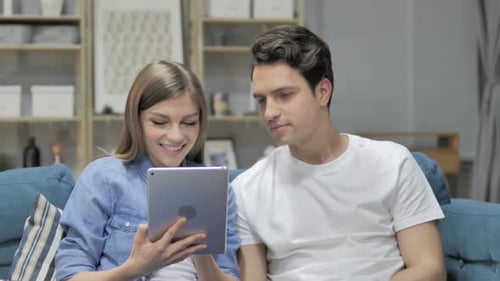 Young Couple Enjoying Tablet at Home on Couch