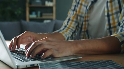 Hands Typing on Laptop Keyboard at Home
