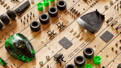 Plusieurs pièces de voiture RC organisées sur un plancher en bois pour un assemblage futur. 4KHD
