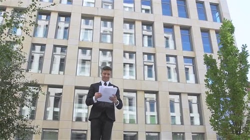 Young Businessman Throwing Paper with Arms in the Air, Slow Motion