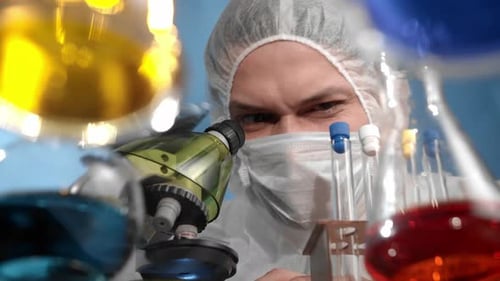 Scientist Uses Microscope and Test Tube in Laboratory