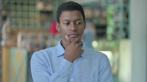 Porträt eines nachdenklichen jungen afrikanischen Mannes, der denkt und sich Ideen macht