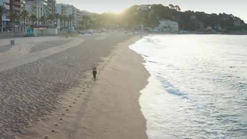 Drone View of Sporty Female Running Along Beach