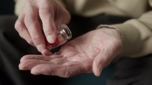 Man Hold Many Multicolored Pills in a Senior's Hands Antibiotic and Vitamin Drugs