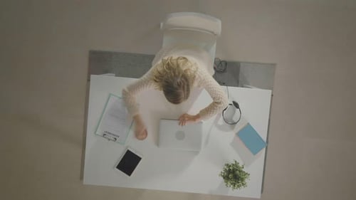 Overhead View: Woman Works at Desk with Devices