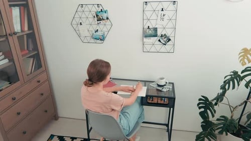 Junge Frau studiert im gemütlichen Zimmer
