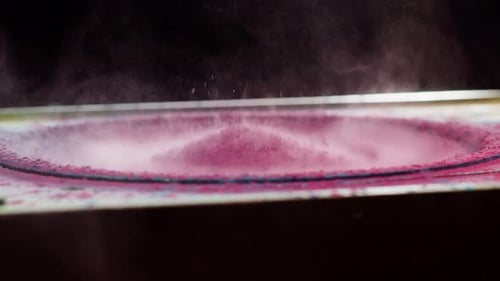 Speaker blasting pink powder in slow motion