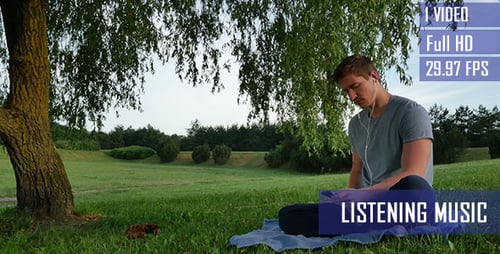 Young Man Listens To Music In The Park