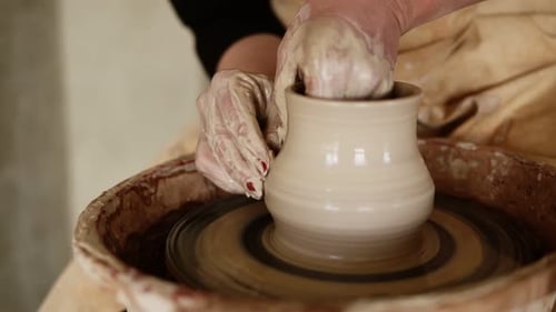 Potter Shaping Clay Vase on Spinning Wheel