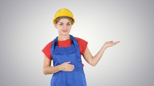Young builder worker woman presenting showing product with