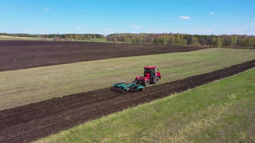 Red Tractor Working at Field