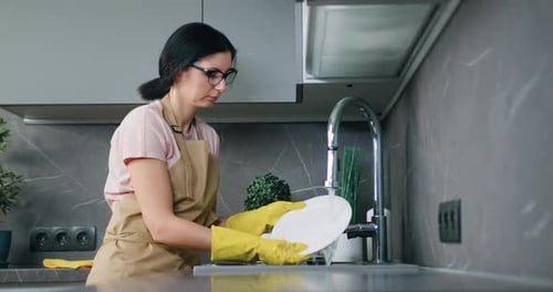 ama de casa morena señora lavando platos en la cocina todos los días en la cocina de estilo interior moderno
