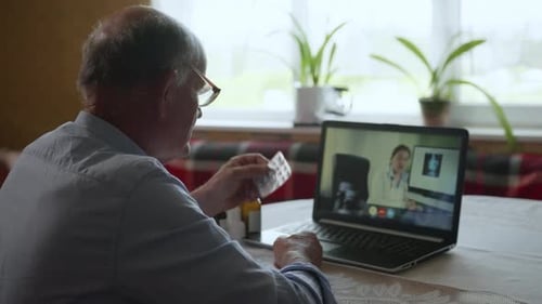 Senior Man Uses Laptop for Telehealth Doctor Visit