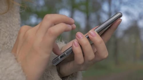 Woman Using Smartphone in Urban Park Setting