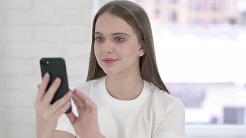 Portrait of Focused Young Woman Using Smartphone
