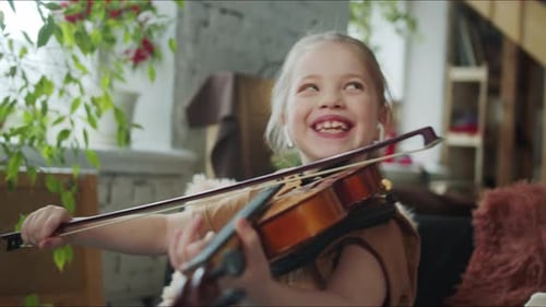 Happy Child Plays Violin at Home with Adult