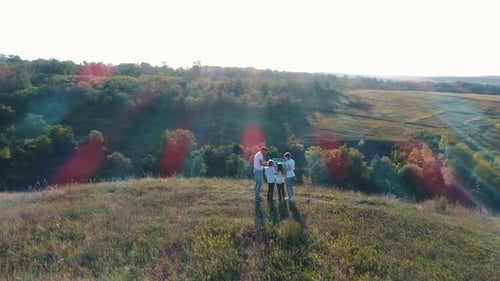 Family Embracing on a Hilltop Overlooking Beautiful Valley