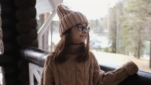Smiling Child Relaxing Outdoors at Lakeside Cabin