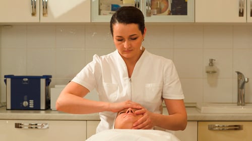 Beautician Gives Facial Massage To Relaxed Woman