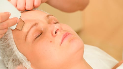 Woman Receiving a Facial Treatment at Spa