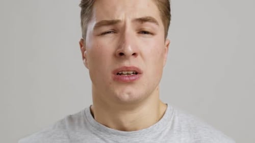 Young Man Sneezing into a Tissue Close-Up