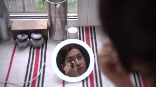 Woman Applies Makeup With Mirror at Home