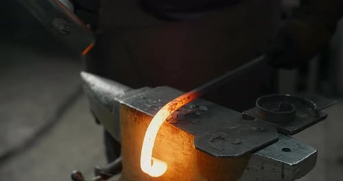 Metal Worker Shaping Red Hot Metal on Anvil