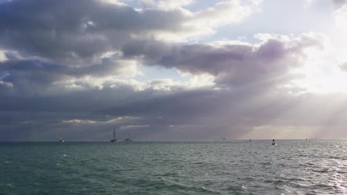 Ocean with boats on a cloudy evening