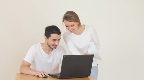 Young Couple Smile and Work at Laptop Together