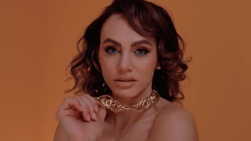 Glamorous Woman Modeling Jewelry in Studio Setting
