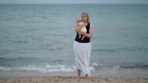 - Mother with Lost Look Holding Baby Being Alone at the Beach Near Sea