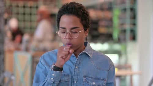 Young Adult Coughing Indoors During the Day