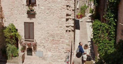 Four Happy Tourist People Walking and Running Amazed Through Small Street Visiting Rural Town of