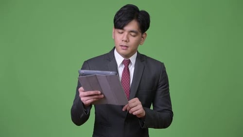 Young Adult Using Tablet in Front of Green Screen