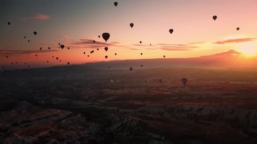 Wunderbarer Sonnenaufgang in Kappadokien erhellender Bergrücken und Himmel mit fliegenden Luftballons