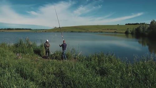 Two Young Guys Are Fishing on the Lake