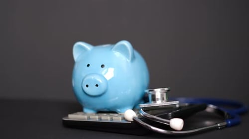 Piggy Bank with Stethoscope and Calculator on Black Background Health Insurance Concept
