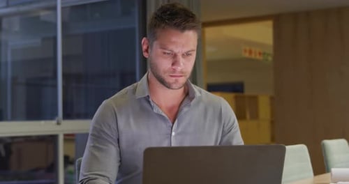 Businessman working on laptop in a modern office