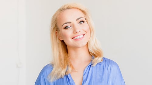 Smiling Woman with Blonde Hair in Blue Shirt