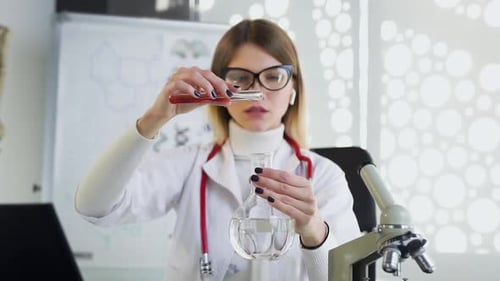 Female Scientist Pouring Liquid Into Flask