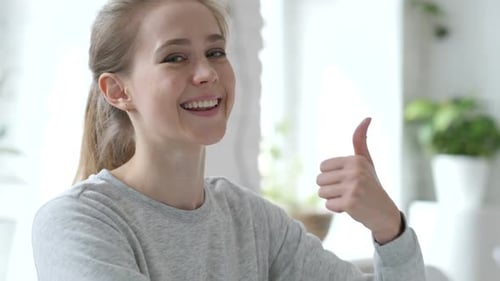 Thumbs Up By Young Woman at Work Both Hands